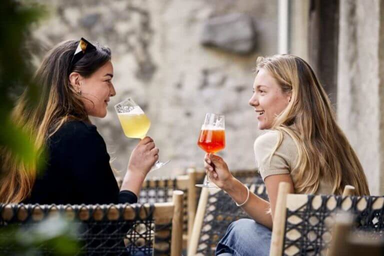Besucherinnen trinken im großen Biergarten den Decantei-Aperitif