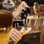 Eine Barkeeperin schenkt an der Bar in Brixen ein Bier ein.